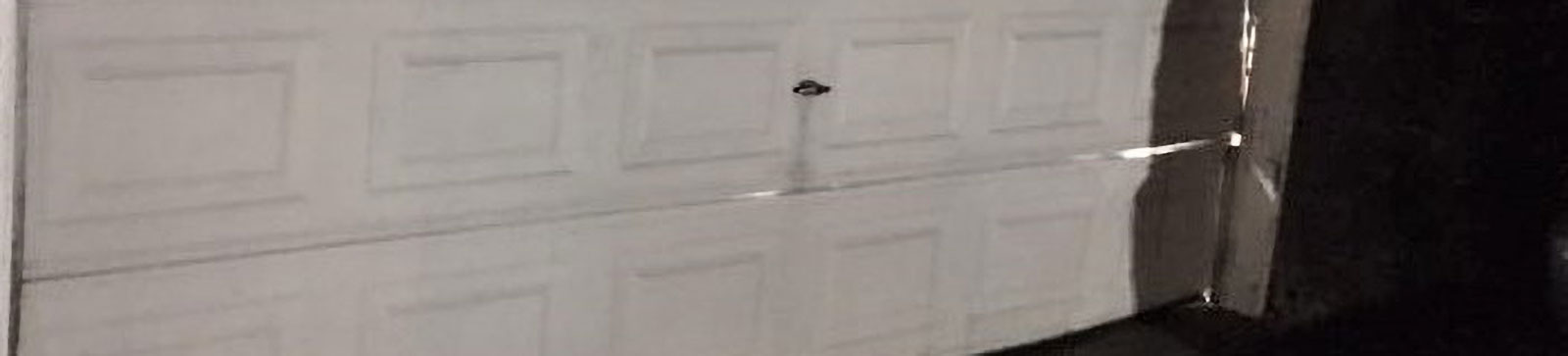 Badly dented residential garage door before new installation in Cumming, GA